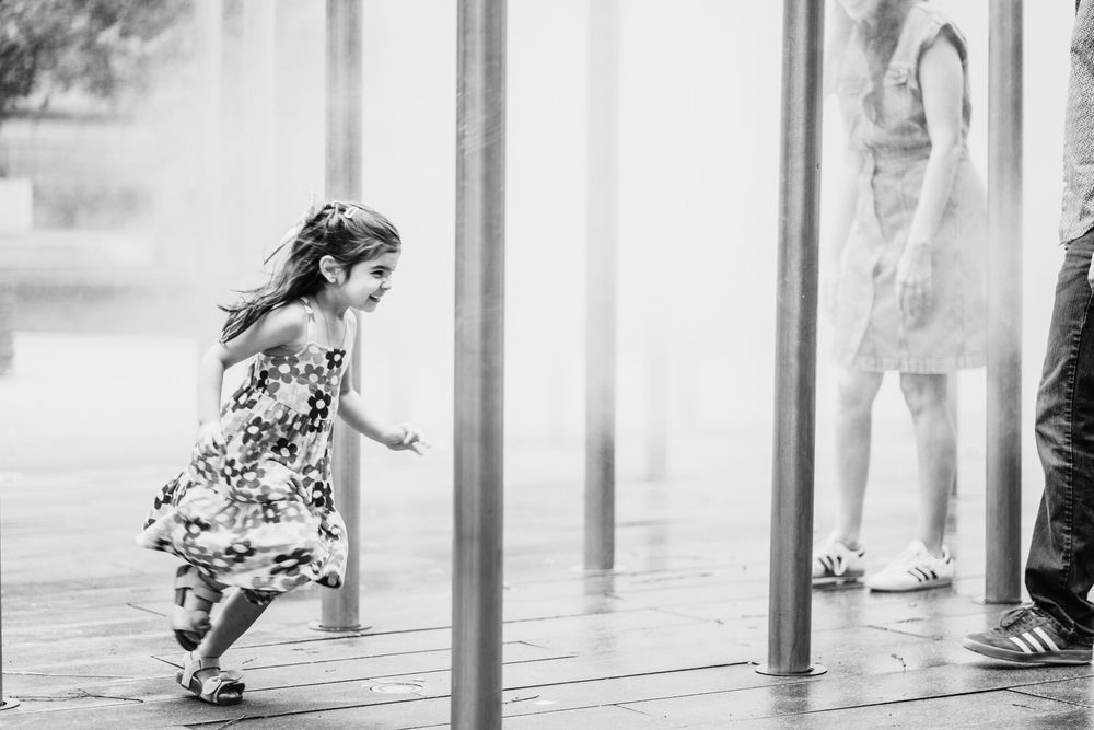 A young girl runs through a sprinkler water feature at the Children's Museum of Pittsburgh. Shannon Konek, Pittsburgh Photographer