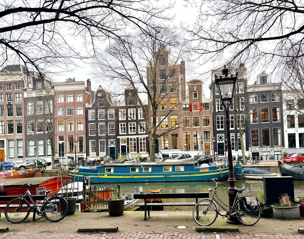 Historic Dutch canal houses and boats line a waterway in Amsterdam's charming city center.