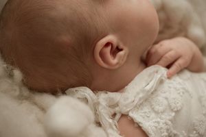 A collage of intimate newborn photography moments showing gentle hands holding and cradling a baby in soft lighting.
