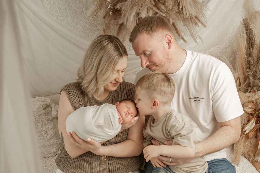 A series of intimate maternity photos showing a couple embracing and sharing tender moments on a beige backdrop.