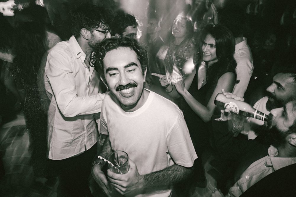 Black and white photo capturing joyful celebration at a nightclub party.