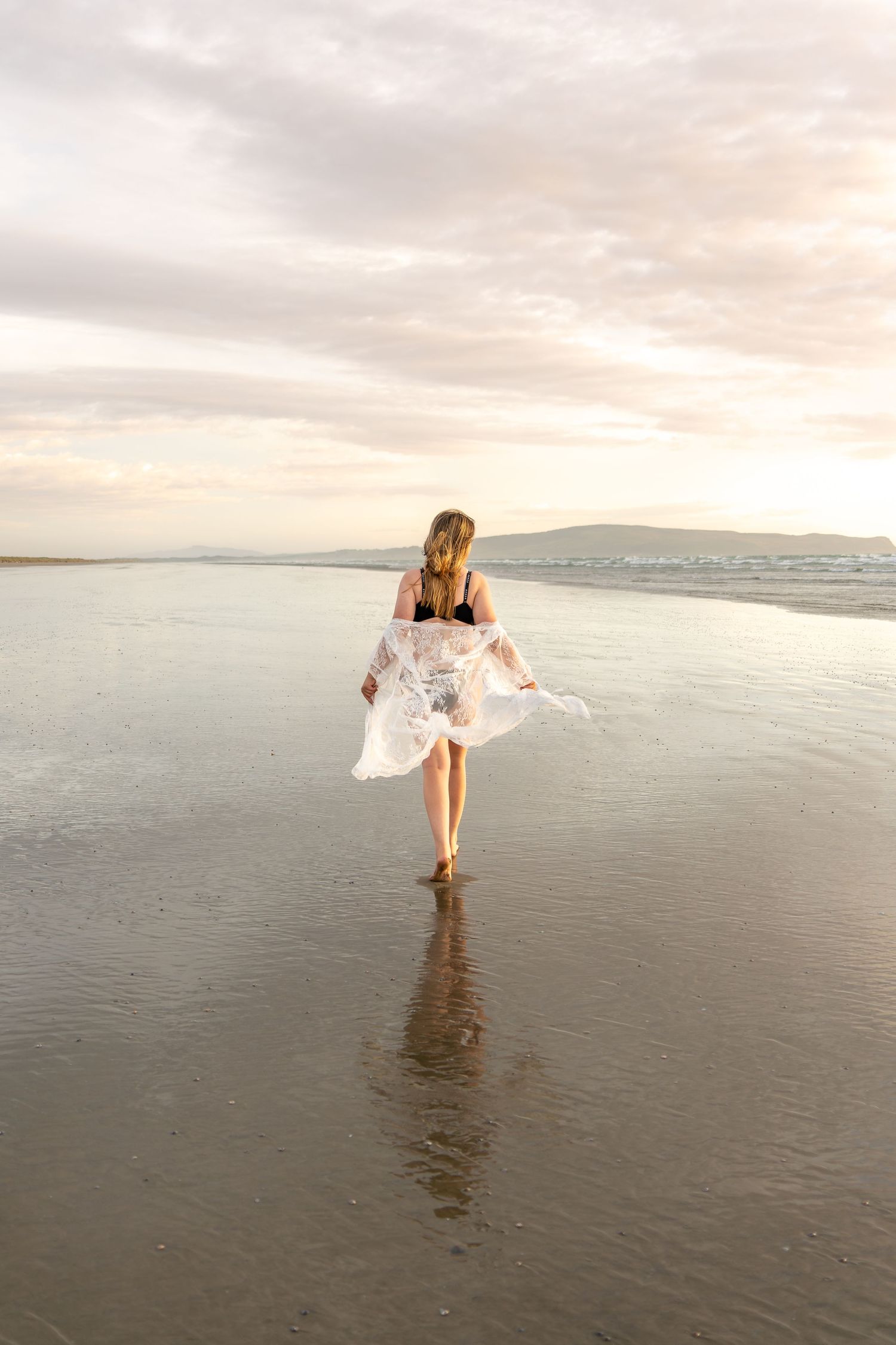 Woman in a robe walking on the beach
