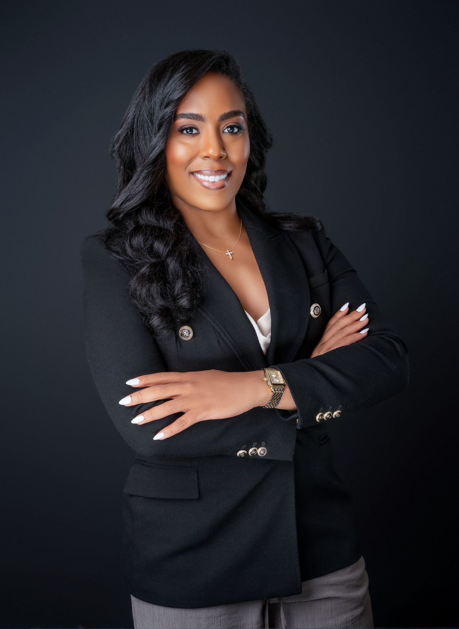 Studio portraits featuring black blazer and confident poses against dark backdrop.
