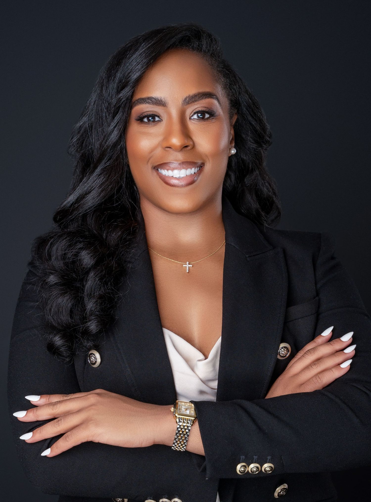 Professional headshots showing bright smile and black blazer against dark background.