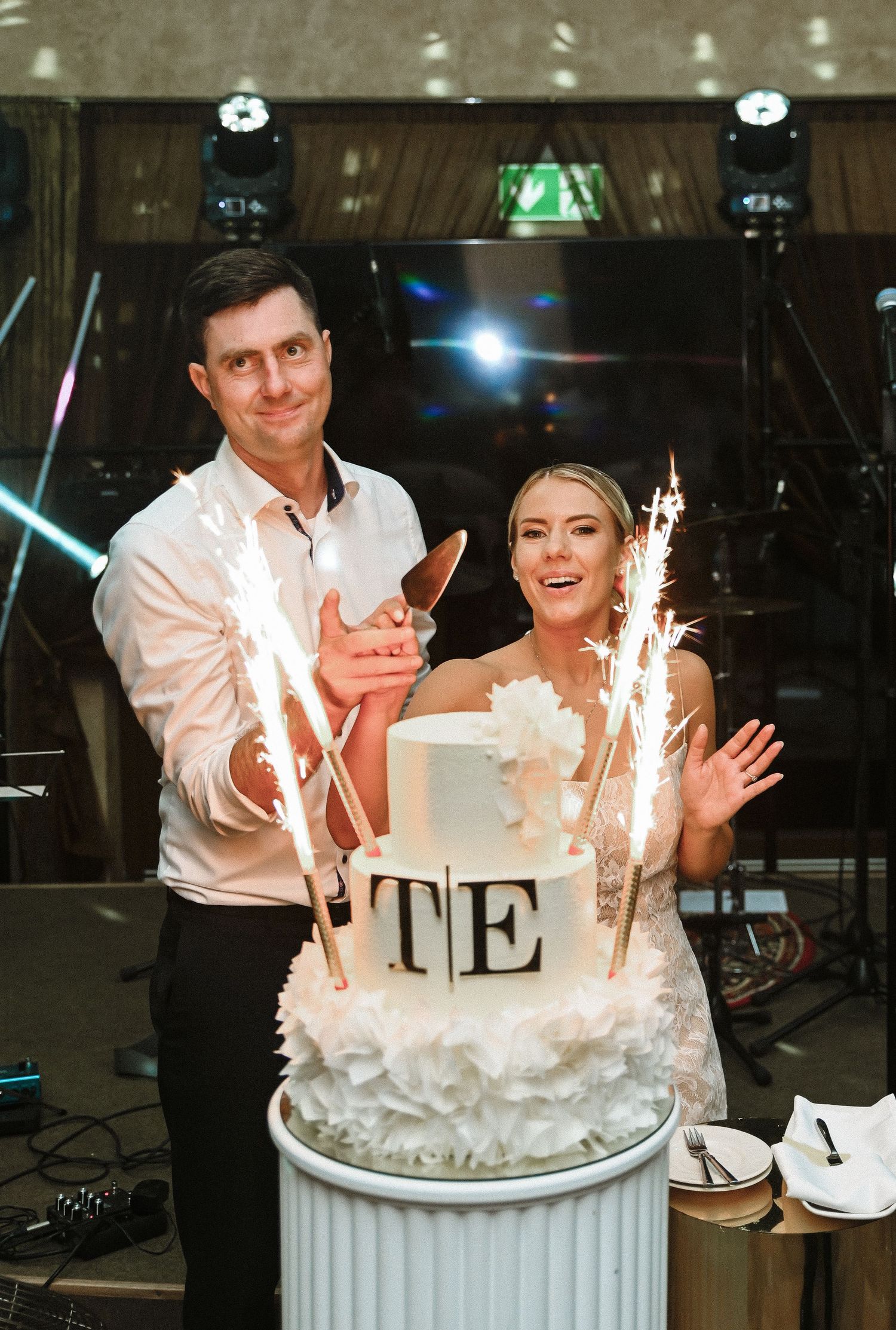 Wedding cake decorated with sparklers and white floral details creates a magical moment during reception.