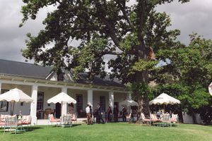Wedding guests enjoying pre-drinks in the gardens at La Cotte, Cape Winelands