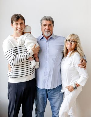 A family in white and striped clothing poses against a white wall in a series of candid photos showing warm embraces.