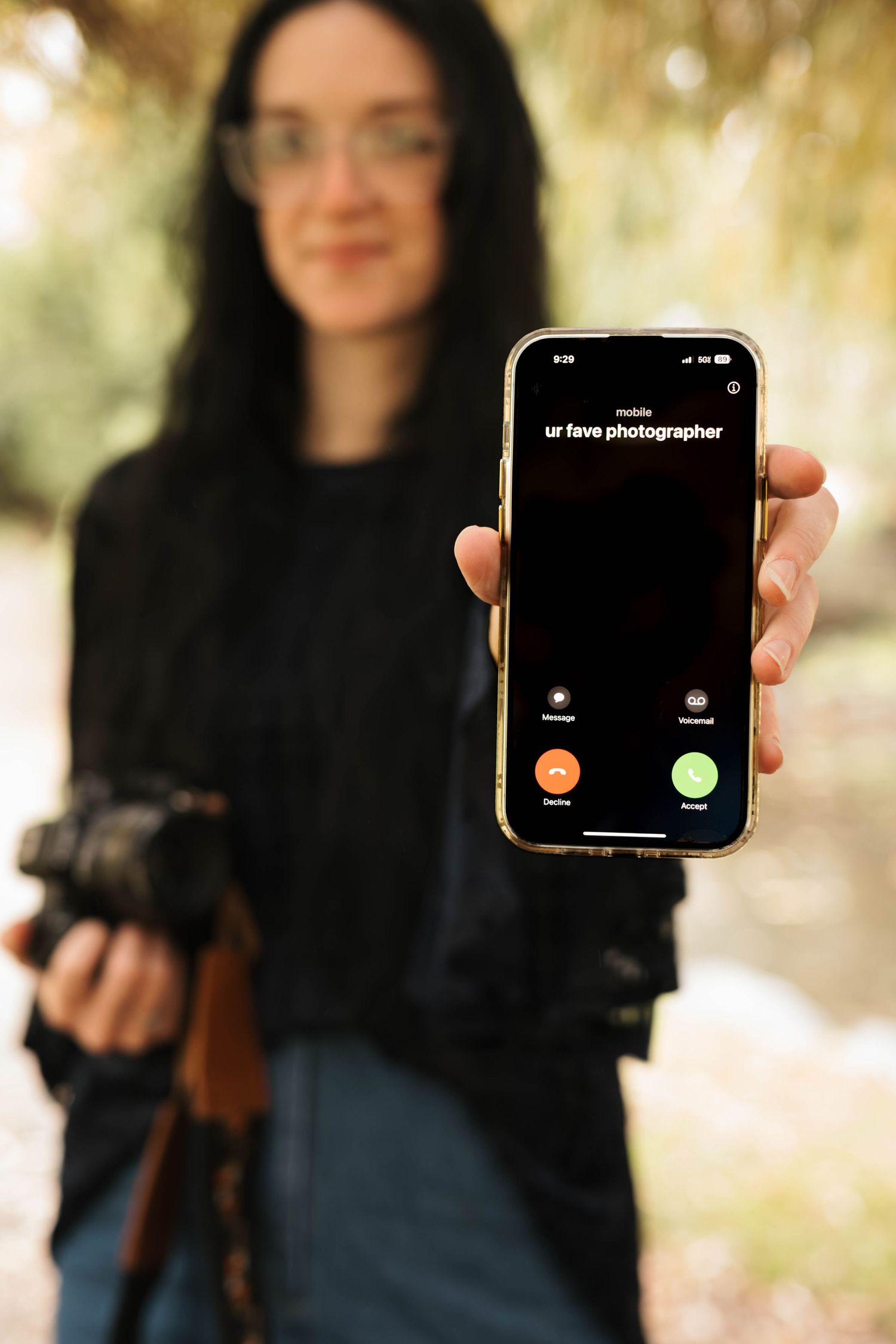 Photographer holding phone displaying incoming call from ur fave photographer.