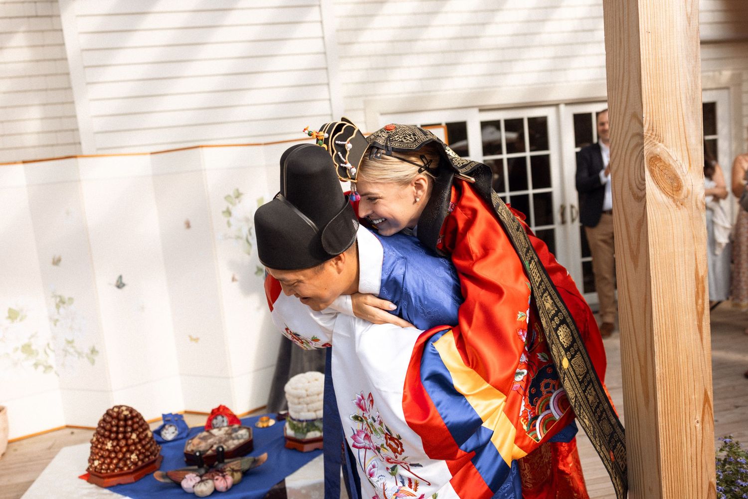 Traditional Korean wedding ceremony with participants wearing hanbok attire on an outdoor deck.