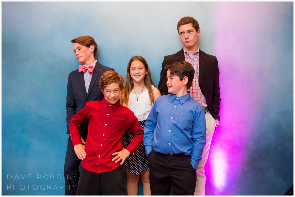 Group poses together at a celebratory event with pink and blue lighting effects.
