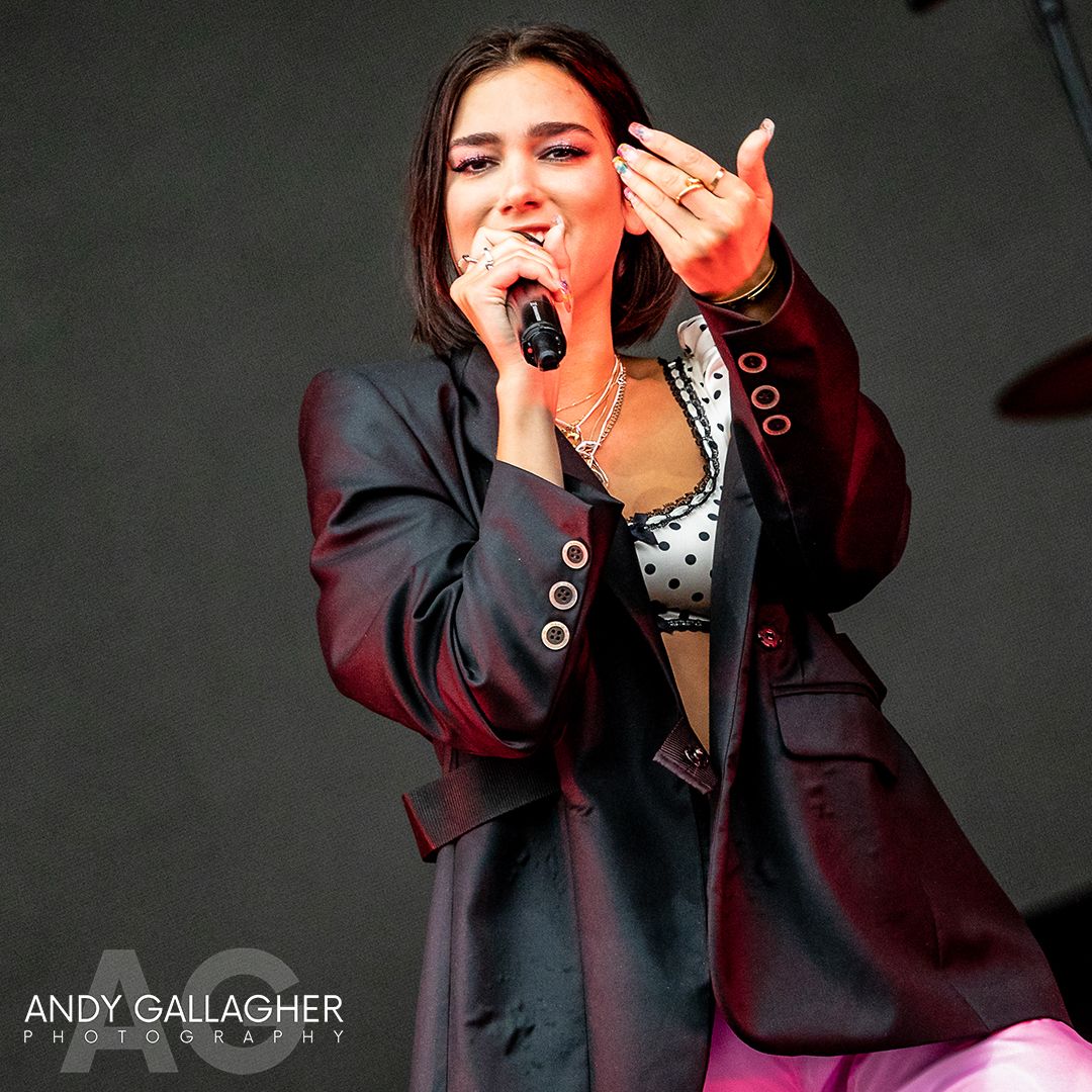 Live music photograph of Dua Lipa singing on stage with vibrant lighting and audience atmosphere photographed by Andy Gallagher