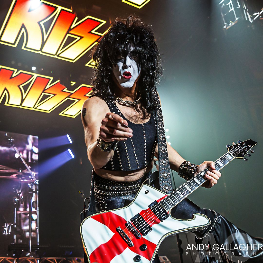 KISS band members perform onstage with signature guitars and face paint during an energetic rock concert performance by Andy Gallagher
