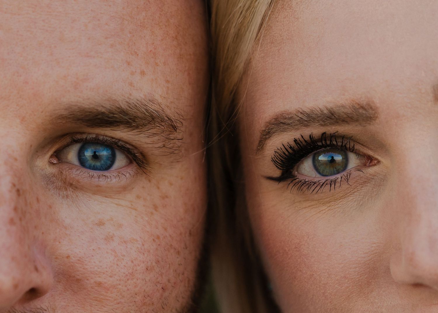 A close up artistic detail of eyes with freckles and natural features in warm lighting.