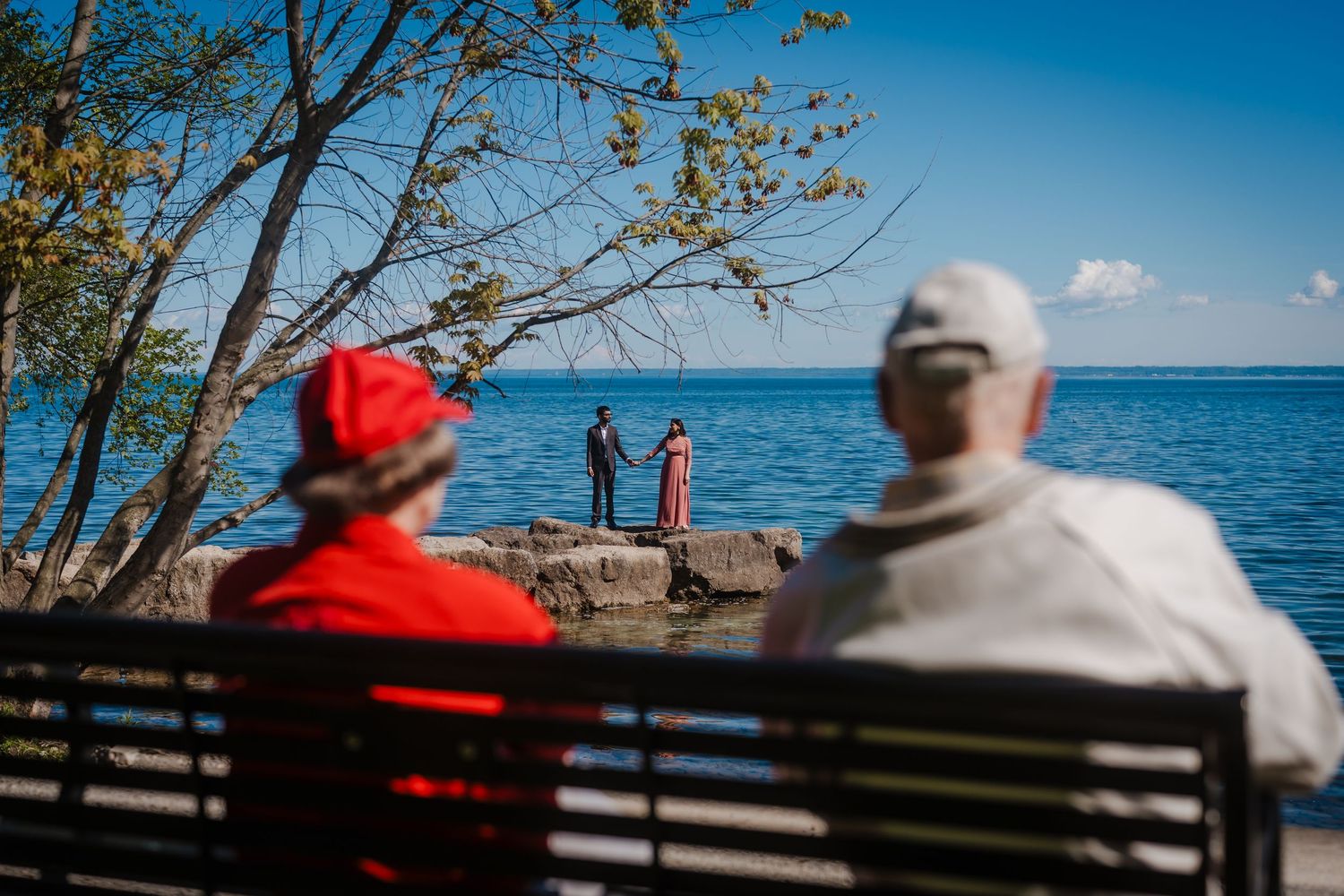 A sequence of scenic oceanfront views shows couples relaxing on wooden benches overlooking a tranquil blue sea.