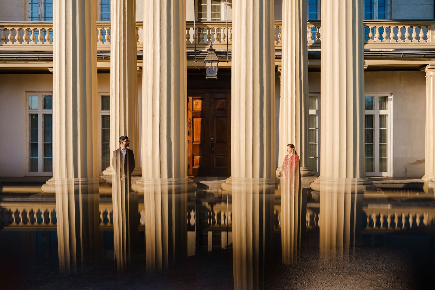 Golden limestone columns cast dramatic shadows across a classical building facade in warm sunlight.