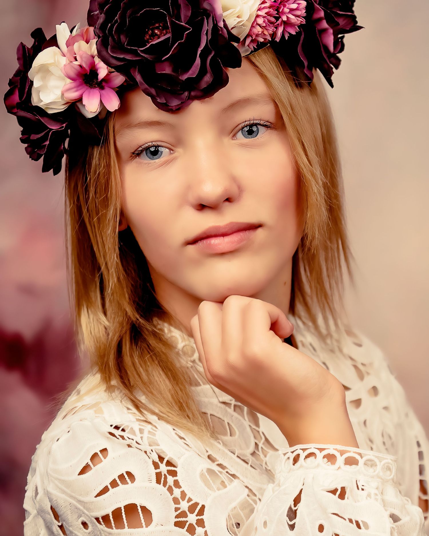 Portrait wearing a lace dress and floral crown with dark and pink roses.