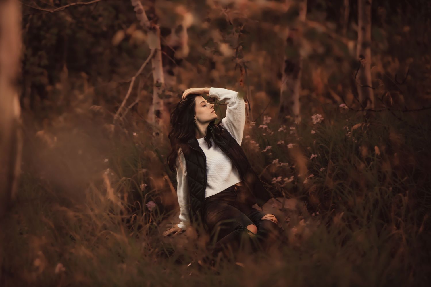 A couple poses intimately among rustic autumn foliage creating a romantic engagement portrait series.