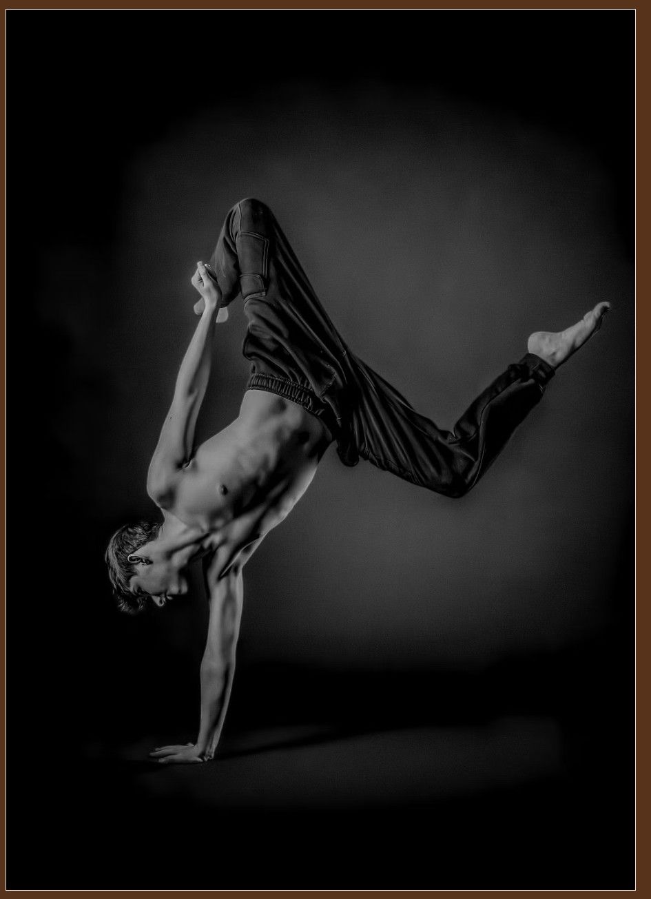 Dramatic black and white sequence captures a dancer performing dynamic handstand movements against a dark background.
