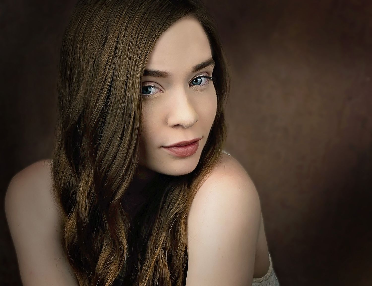 Artistic portrait against dark background showcasing natural beauty and dramatic lighting.