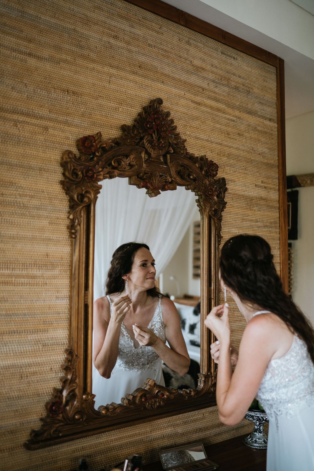 An ornate gold-framed mirror reflects preparations in a warm-toned interior space.