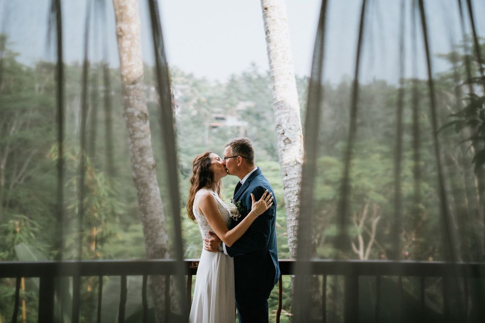 A romantic wedding photo sequence captured in a misty forest setting with tall trees in the background.