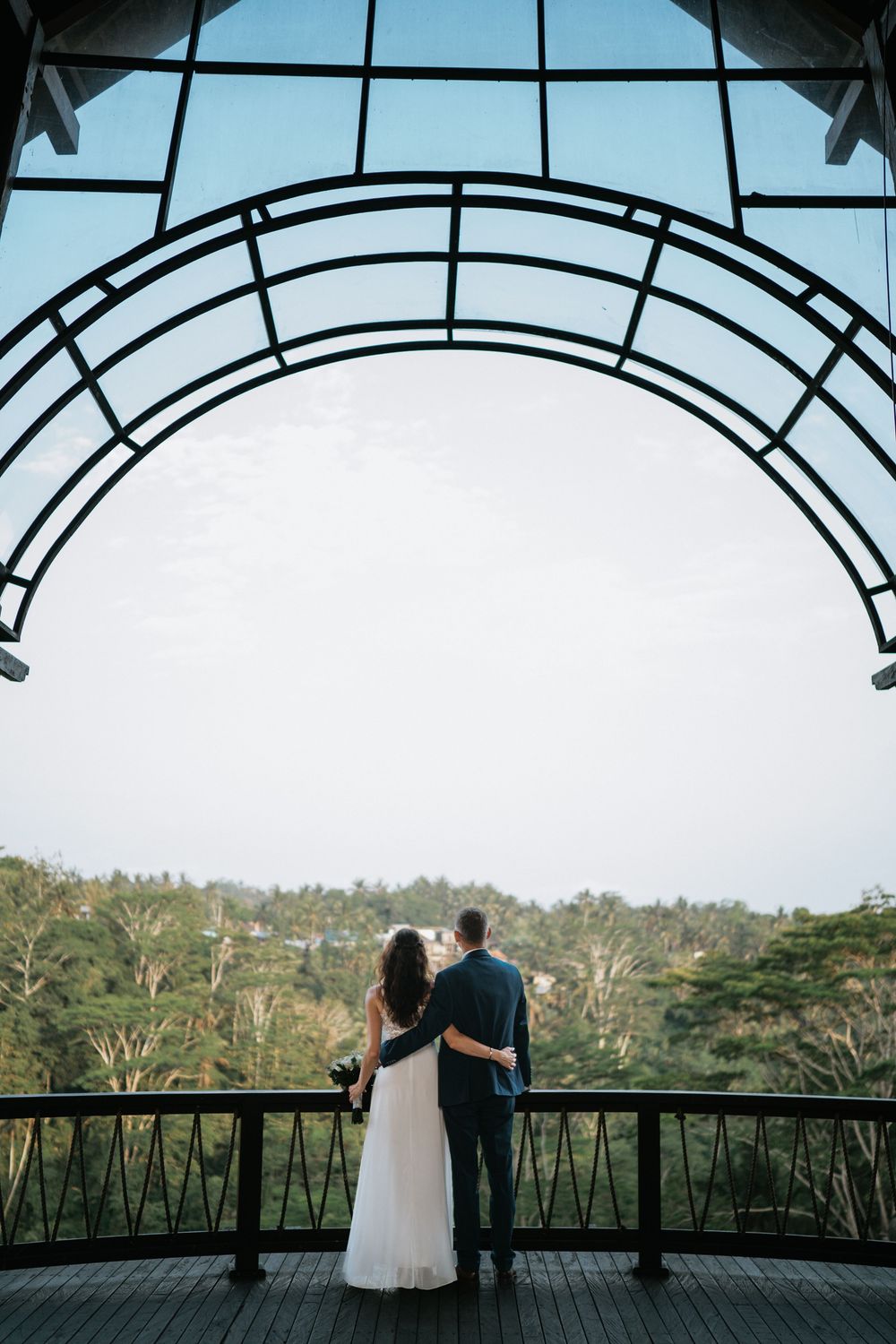 Panoramic wedding venue with glass ceiling and scenic forest views in the background.