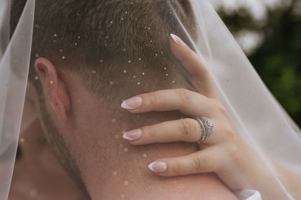 Close-up detail of a delicate bridal veil with soft lighting.