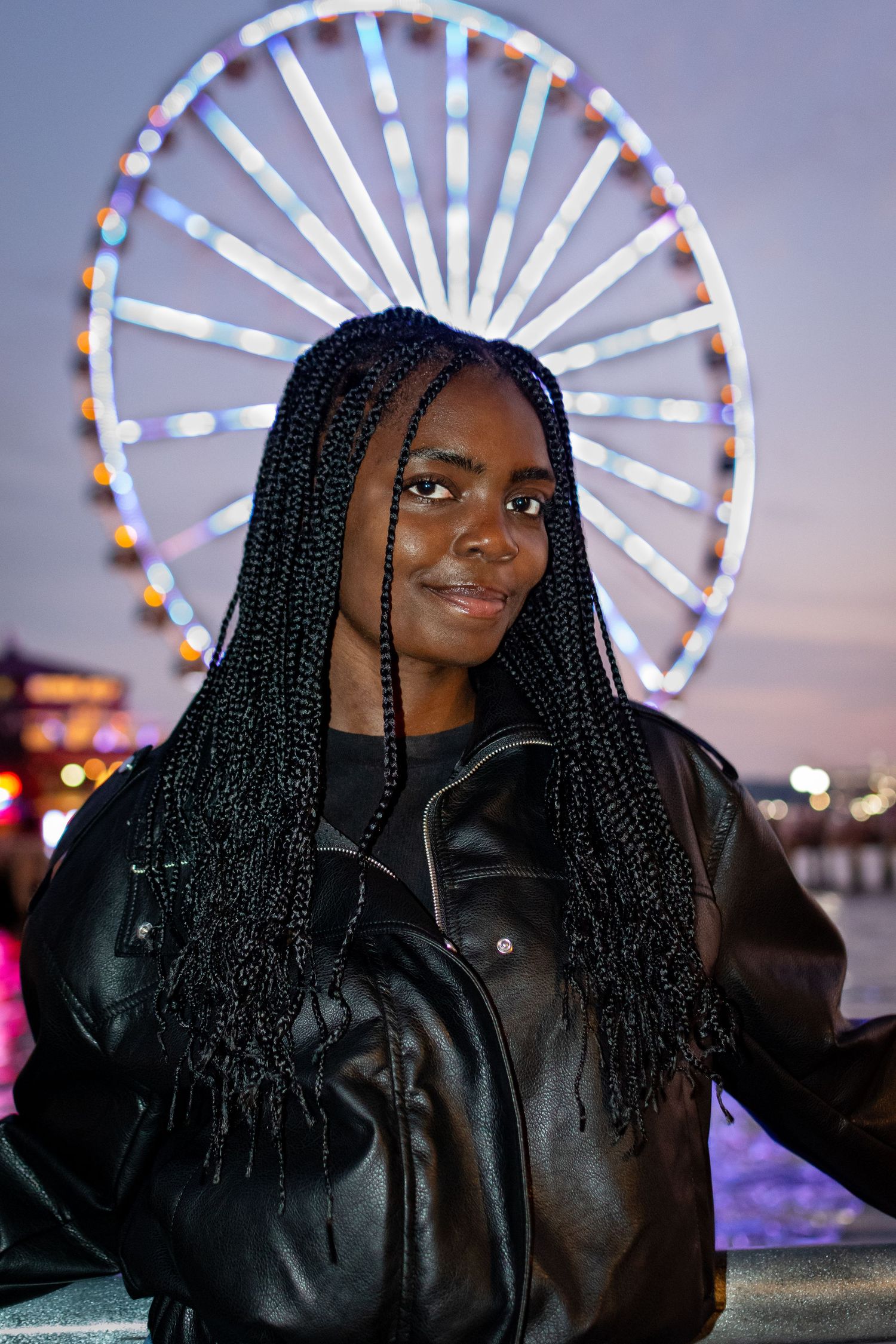 Model posing at Seattle Waterfront with the Seattle Great Wheel glowing at night.