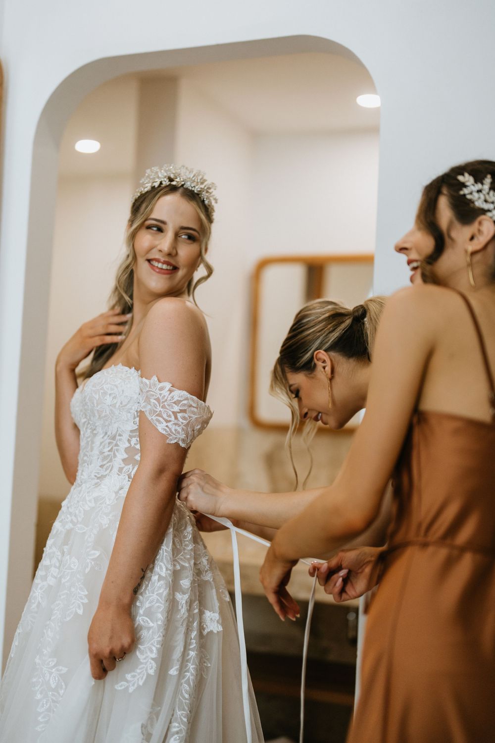 Wedding dress details and preparations with bridesmaids in brown dresses.