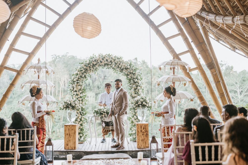 Wedding reception in a rustic vaulted venue with hanging lanterns and floral decorations.