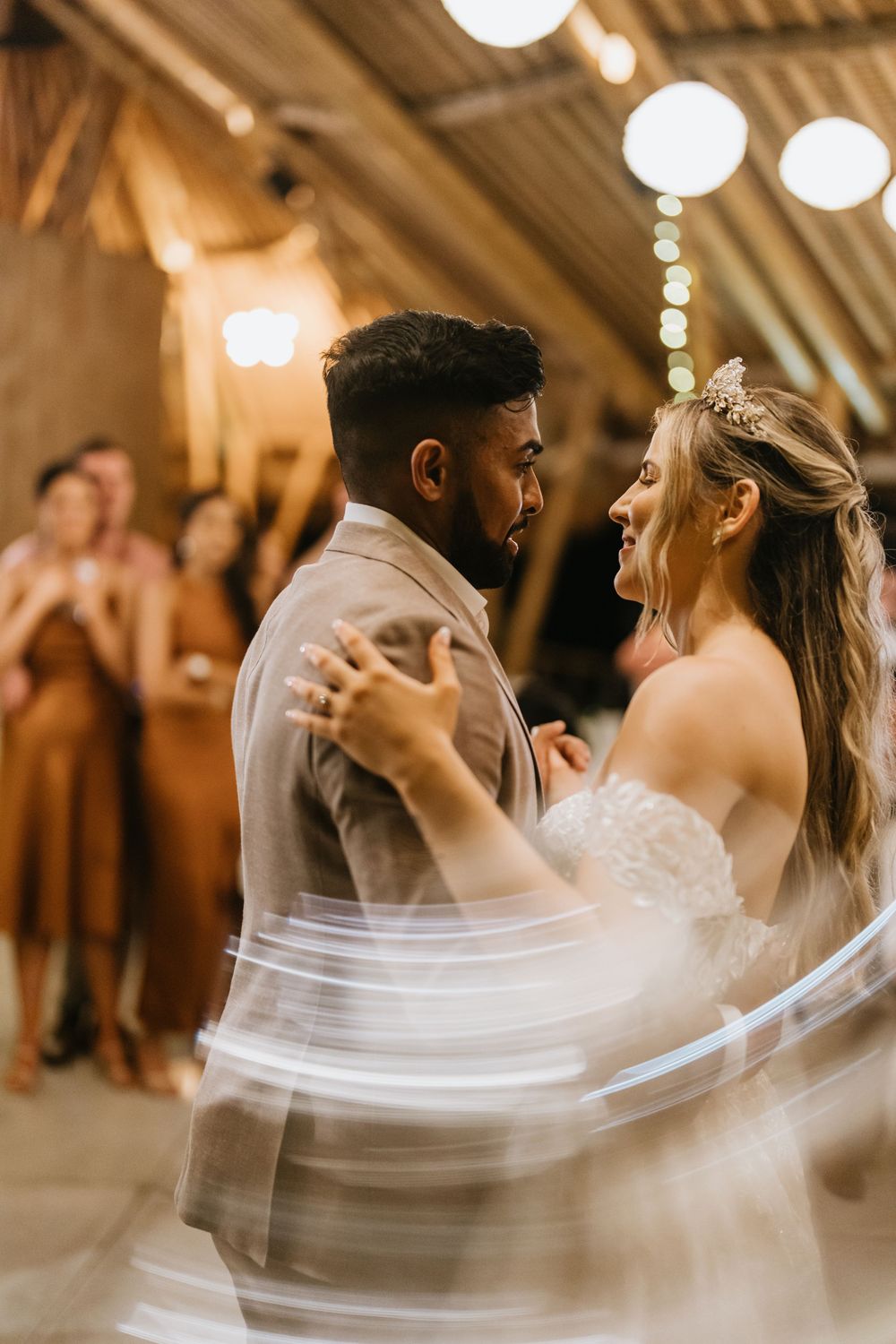 First dance moment in rustic venue with flowing wedding dress and warm lighting.