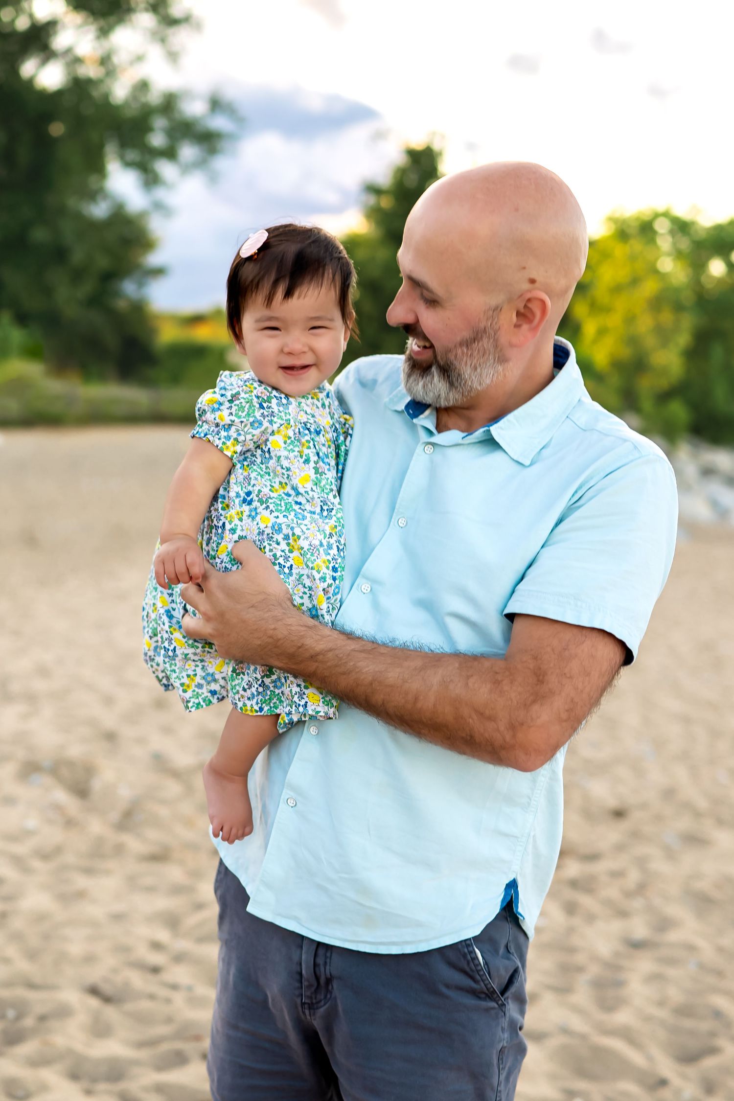 A heartwarming series of photos showing an adult and a baby sharing joyful moments together on a sandy beach.