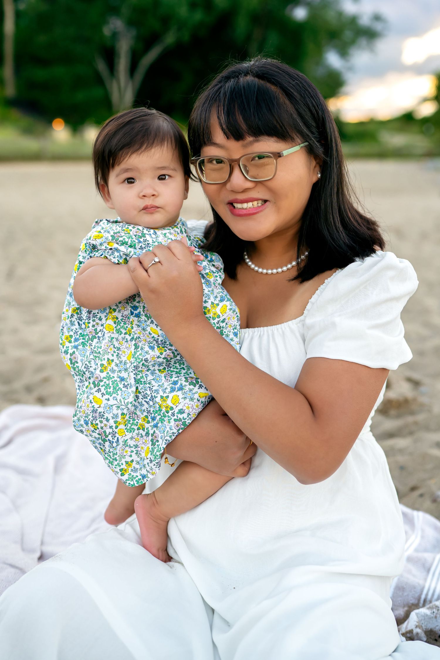 Parent and child in matching white outfits share tender embraces during an outdoor photo session.