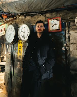 Moody underground photoshoot with vintage clocks hanging from industrial ceiling.