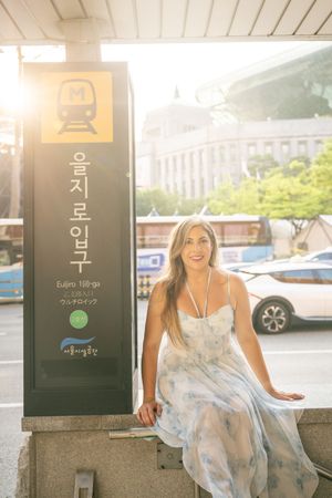 Fashion photoshoot at a modern subway station entrance with bright summer lighting.