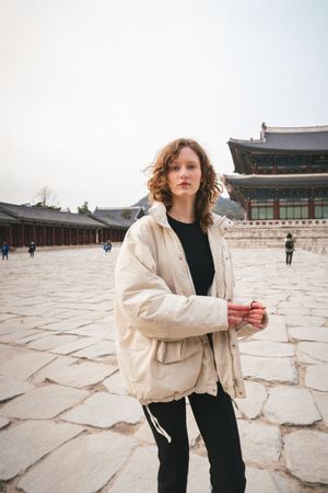 Artistic photoshoot at Korean palace courtyard with traditional stone architecture.