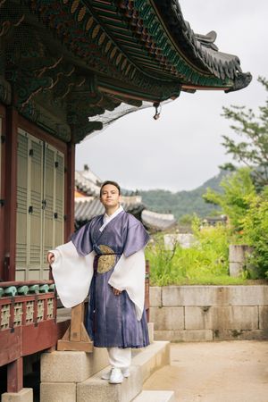 Traditional Korean architecture photoshoot with ornate temple roofs and natural scenery.