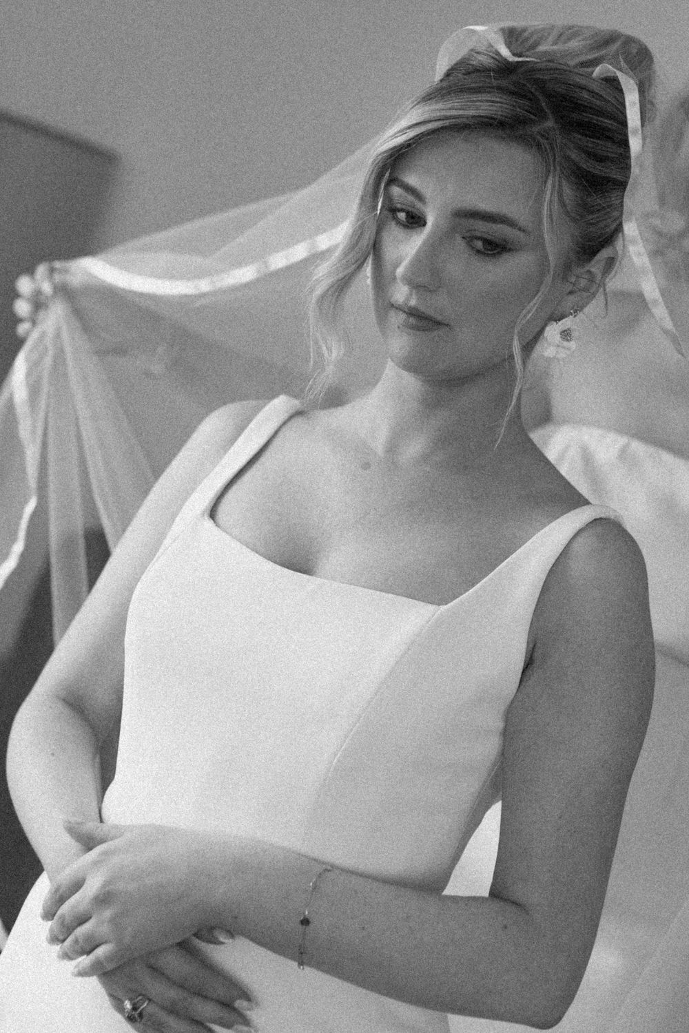 A bride adjusts her white wedding veil in a series of black and white photographic moments showing movement and elegance.