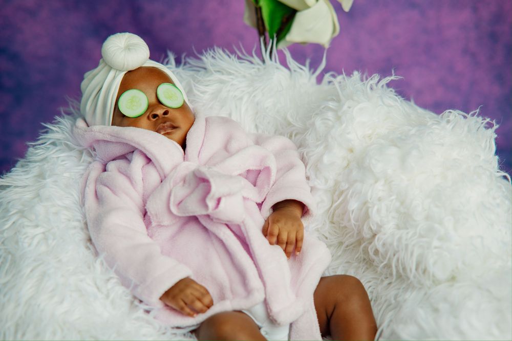 Baby resting on soft white fur with pink accents.