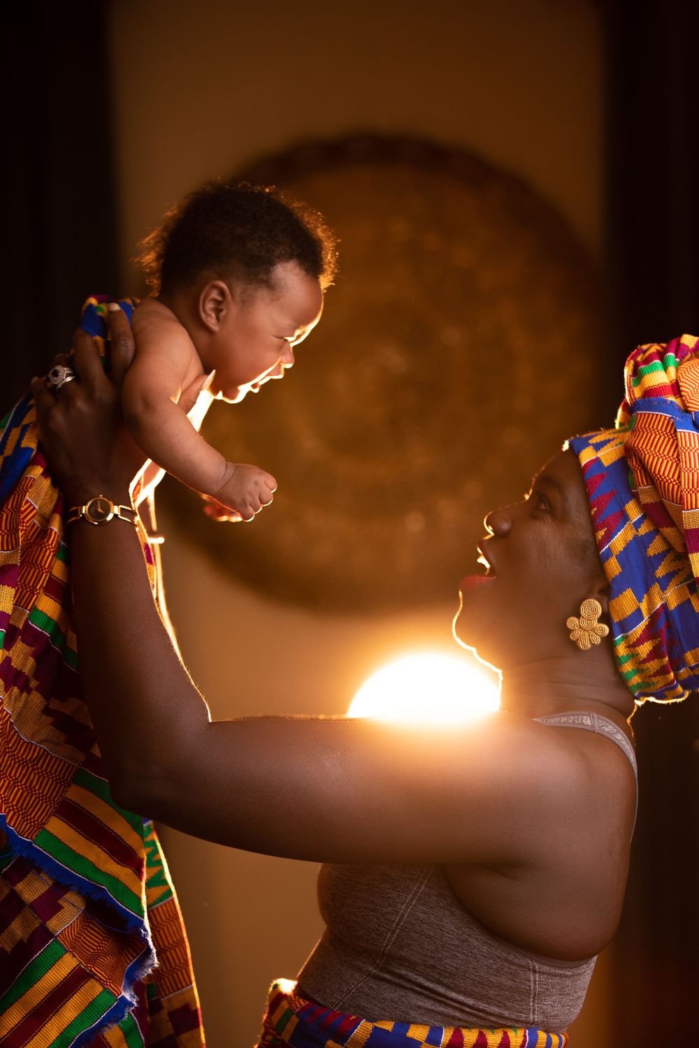 Dramatic side-lit portrait showing movement in traditional African attire with streaming light effects.