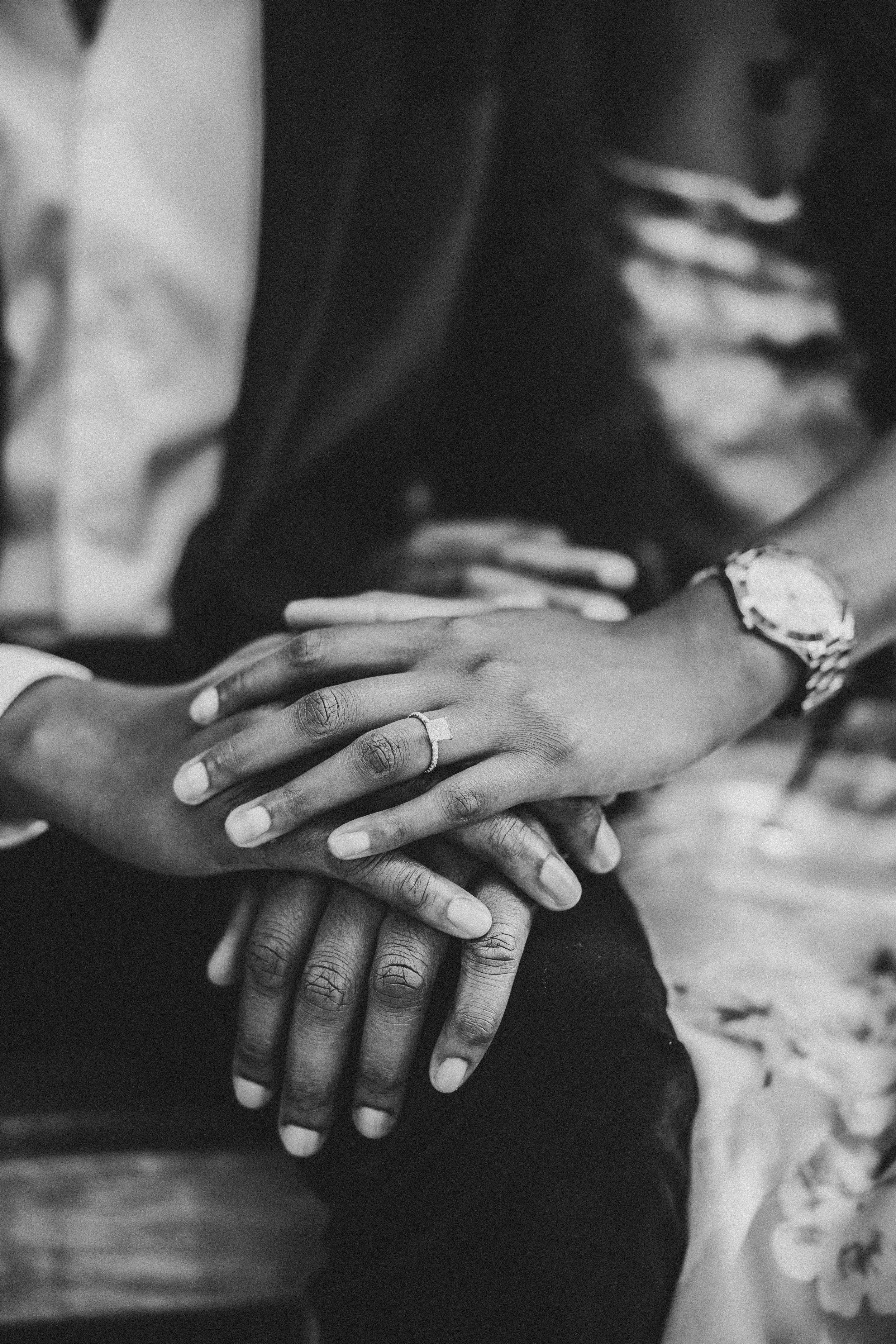 Black and white close-up photo of hands with new engagement ring
