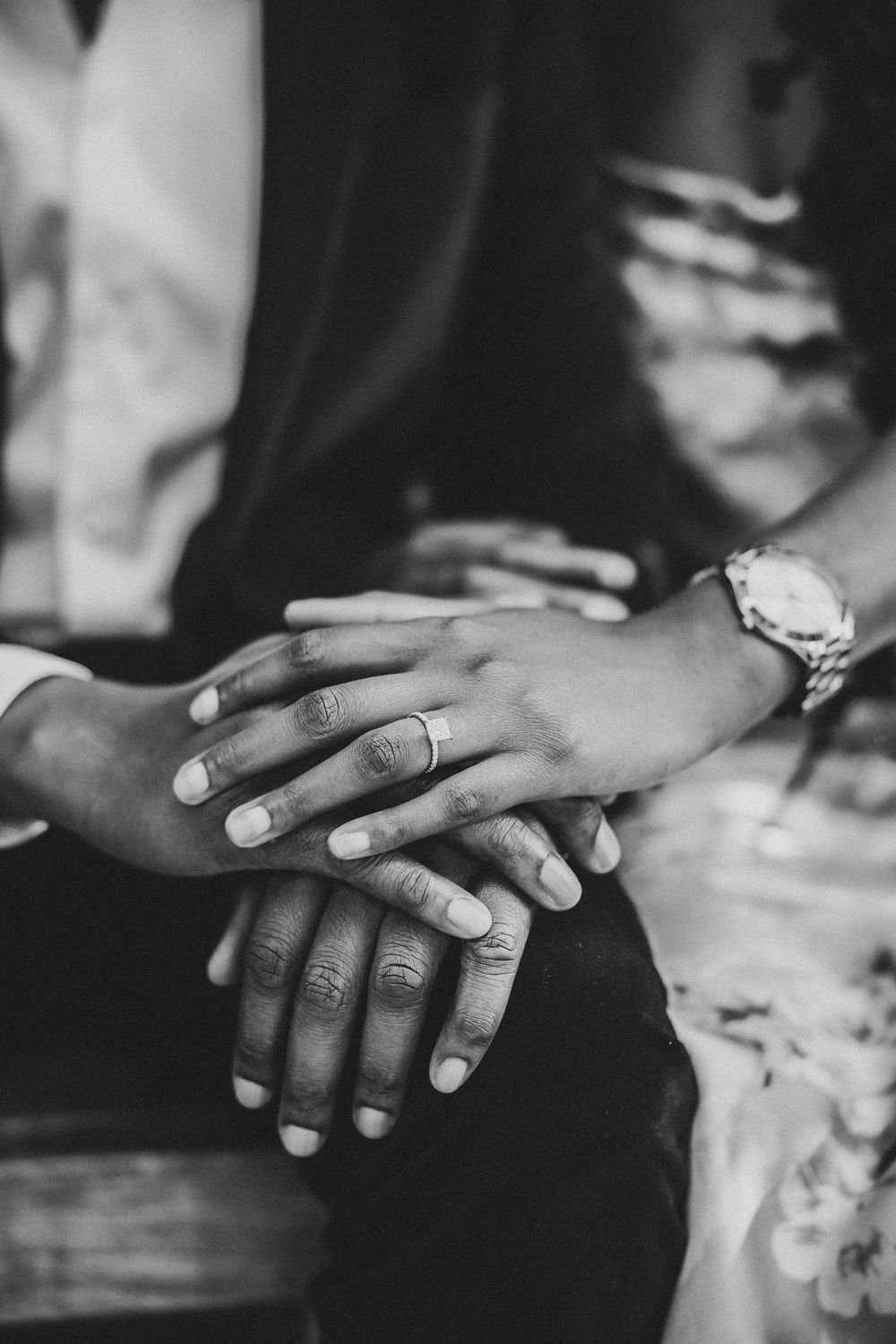 Black and white close-up photo of hands with new engagement ring