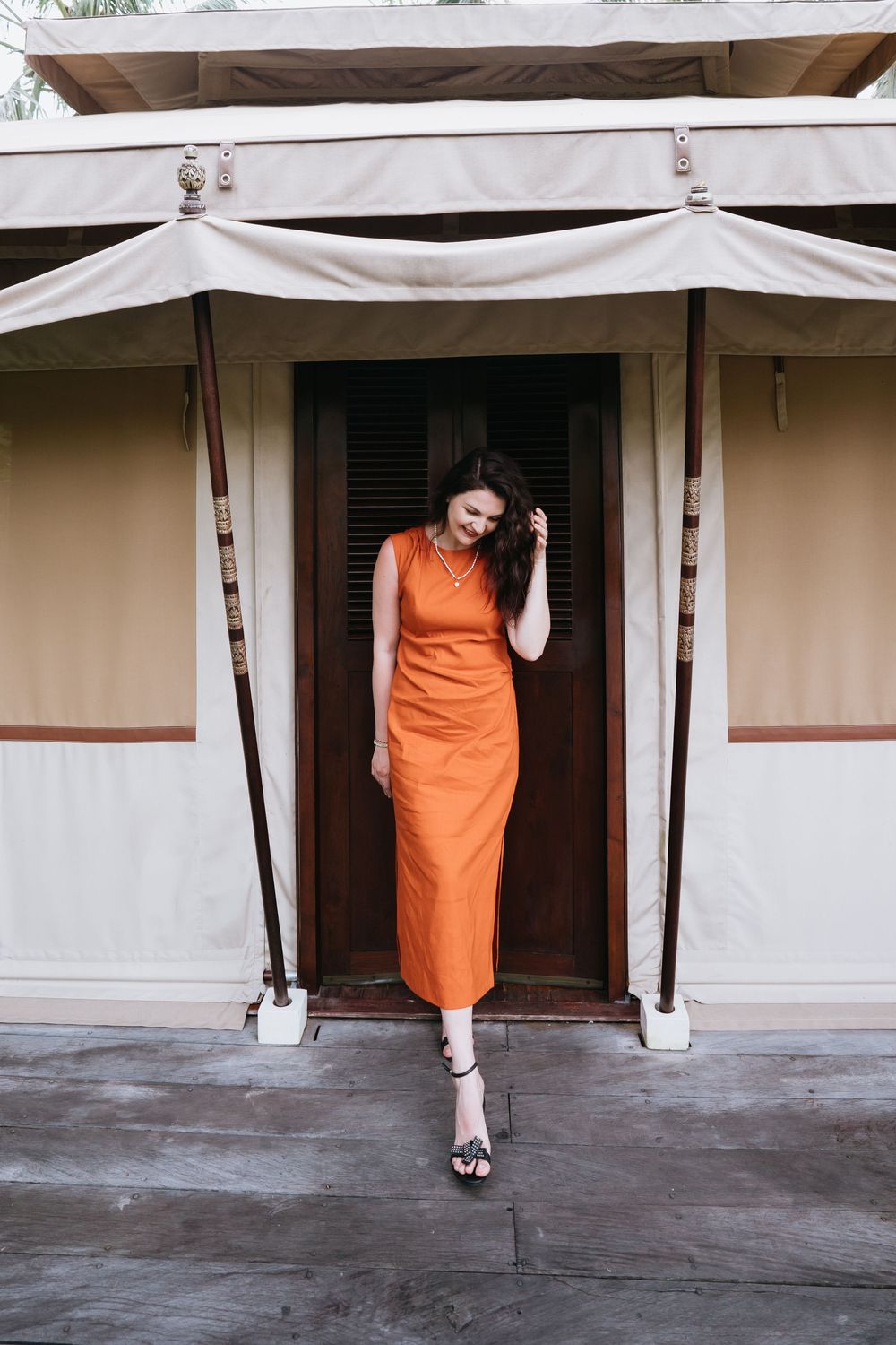 Sequential photos showing movement in orange dress against white colonial architecture.