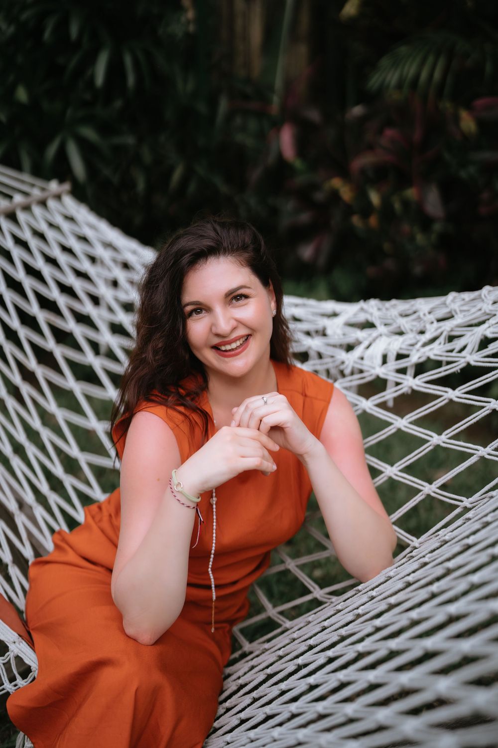 Joyful poses captured in a white hammock surrounded by tropical greenery.