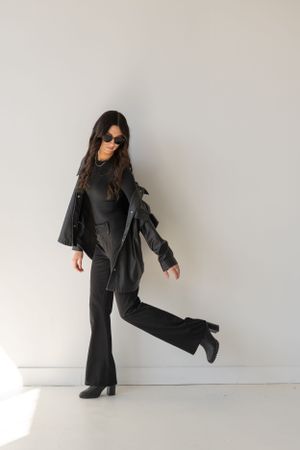 Dynamic fashion poses in all-black ensemble against white studio background.
