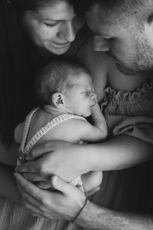 Intimo ritratto di famiglia in bianco e nero con neonato.