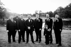 Black and white portrait of groomsmen and ring bearer in formal suits.