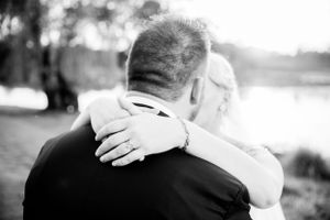 Intimate black and white photo of an embrace at a wedding.