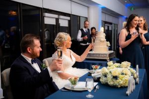 Newlyweds share a moment while cutting their wedding cake at an elegant reception.