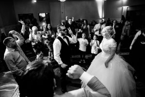 Black and white photo of wedding guests dancing and celebrating at the reception.